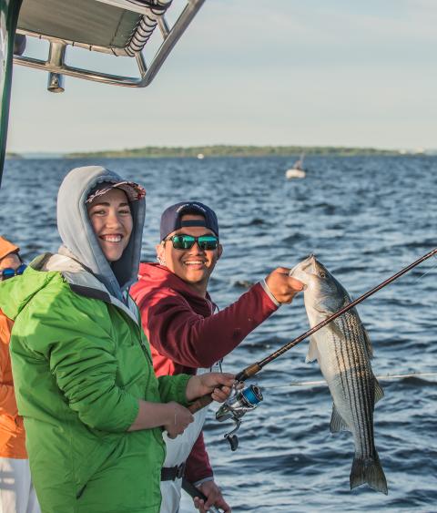 Two anglers with striped bass