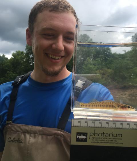 Colt Holley (MS student) with a longnose darter he captured from Lee Creek.