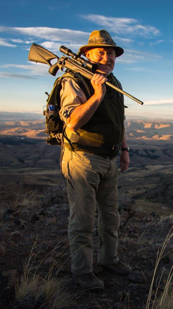 Doug Painter holding shotgun with mountain view behind