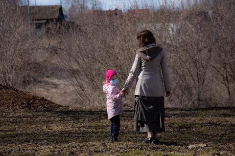 Mother and daughter outdoors wearing protective masks